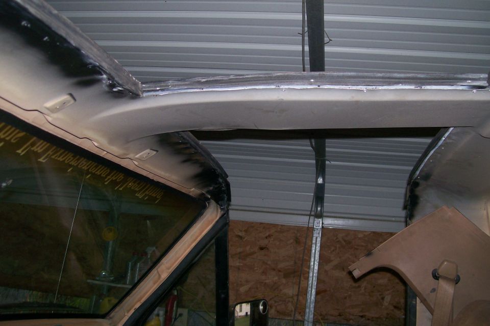 Interior view of vehicle headliner and windshield frame during modification.