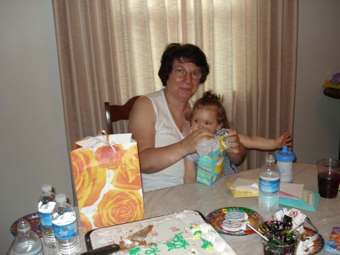 2000 Ford Crown Victoria - A woman and a young child are seated at a table set for a celebration, with a cake and gifts present.