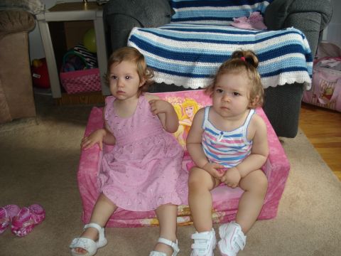 2000 Ford Crown Victoria - Two young girls sit on a pink child's chair with a Disney Princess theme.