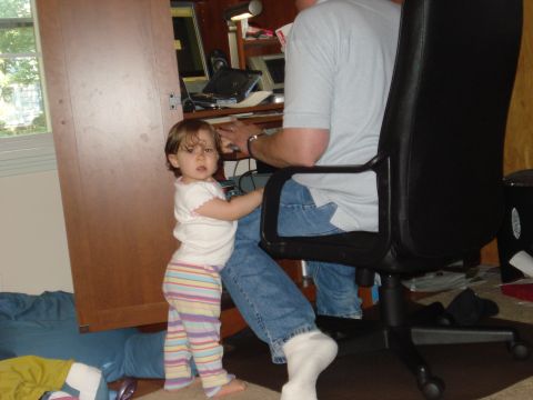 2000 Ford Crown Victoria - A young child stands near a desk where an adult is seated at a computer.