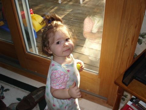 2000 Ford Crown Victoria - A young child looks towards the camera while standing next to a wooden-framed glass door.