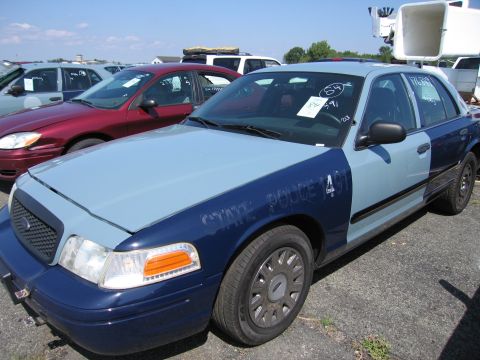 2001 Ford Crown Victoria - This 2001 Ford Crown Victoria police car is parked in a lot with other vehicles.