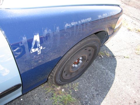 2001 Ford Crown Victoria - The side of a police car shows the number 14 and partial text on its fender.