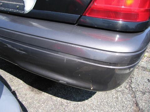 2001 Ford Crown Victoria - Close-up view of the rear bumper and taillight of a vehicle.