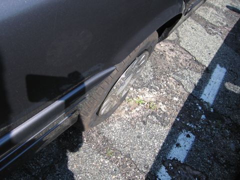 2001 Ford Crown Victoria - Close-up view of a car's fender and wheel, showing the tire and hubcap.