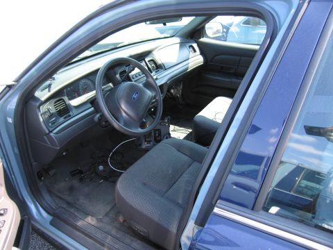 2001 Ford Crown Victoria - The interior of a blue 2001 Ford Crown Victoria is visible through the open driver's side door.