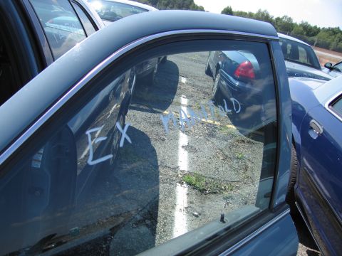 2001 Ford Crown Victoria - Several cars are parked in a lot, with white writing on one window indicating 'EX MANIFOLD'.