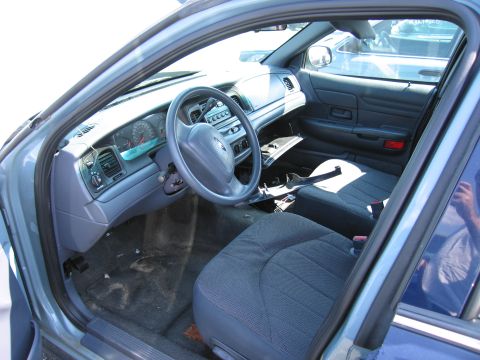 2001 Ford Crown Victoria - The interior of a 2001 Ford Crown Victoria, its dashboard, steering wheel, and front seats.