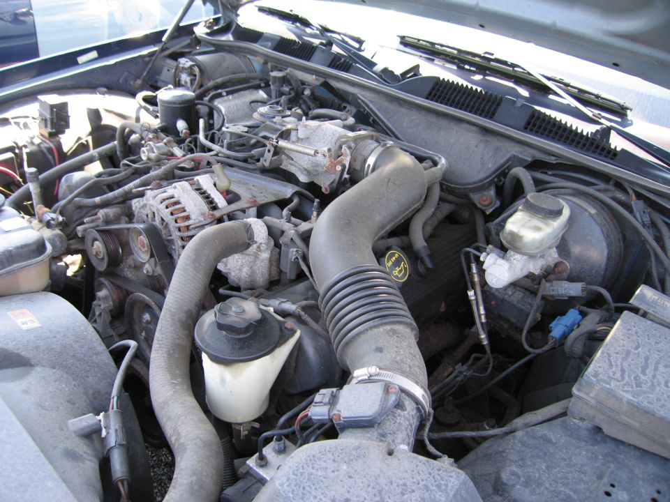 2001 Ford Crown Victoria engine bay with visible V8 engine components, hoses, and wiring