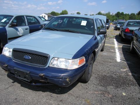 2001 Ford Crown Victoria - This Ford Crown Victoria police car has a two-tone paint scheme and visible damage to its front bumper.