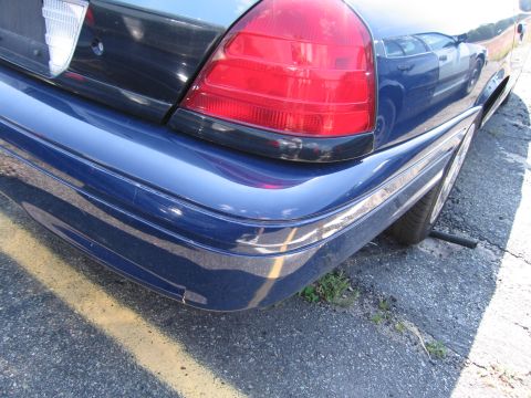 2001 Ford Crown Victoria - Rear view of a blue 2001 Ford Crown Victoria, showing the bumper and taillight assembly.
