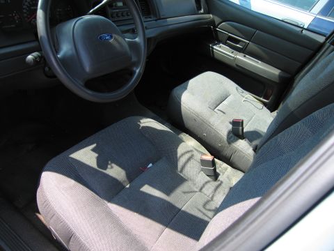 2001 Ford Crown Victoria - The interior of a 2001 Ford Crown Victoria, fabric seats and a Ford steering wheel.