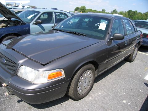 2001 Ford Crown Victoria - A dark gray 2001 Ford Crown Victoria is shown from the front-right in a parking lot with other vehicles.