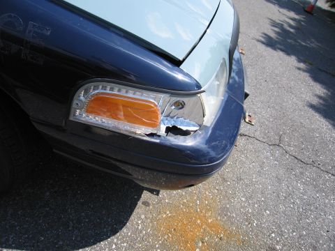 2001 Ford Crown Victoria - Front view of a damaged 2001 Ford Crown Victoria with a cracked headlight and broken grille.