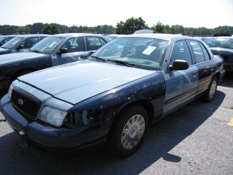 2001 Ford Crown Victoria - This 2001 Ford Crown Victoria police car has been repainted with different colored panels and is missing a headlight.