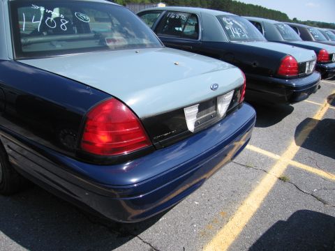 2001 Ford Crown Victoria - Several Ford Crown Victorias are lined up in a parking lot, with visible markings on their windows.