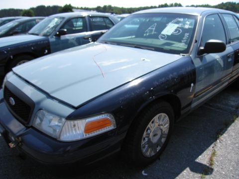 2001 Ford Crown Victoria - A 2001 Ford Crown Victoria is seen in a parking lot, with other similar vehicles in the background.