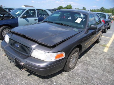 2001 Ford Crown Victoria - Front view of a 2001 Ford Crown Victoria in a vehicle lot, hood ajar.