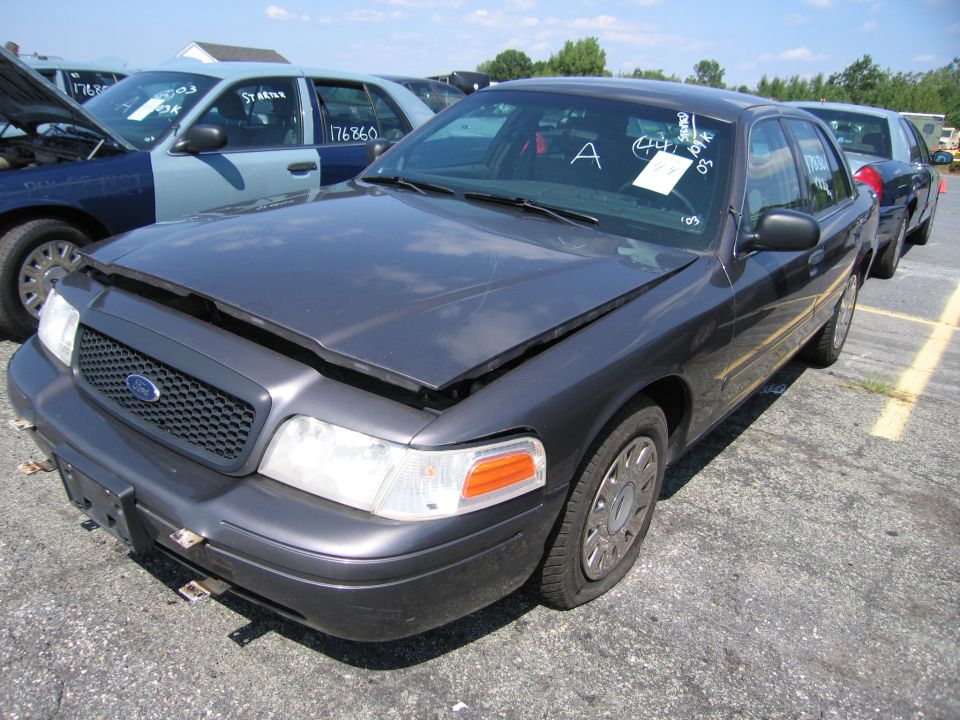 Dark gray 2001 Ford Crown Victoria with hood open, parked in a lot with other vehicles