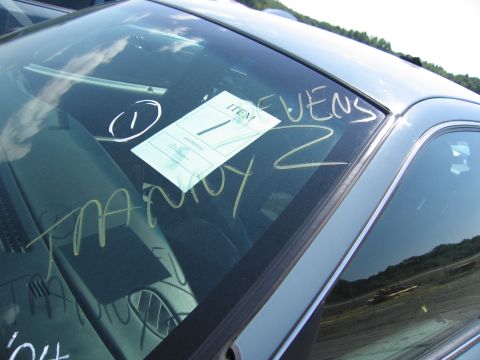 2001 Ford Crown Victoria - Windshield with writing and a tag attached.