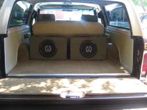 1979 Ford Bronco - The cargo area of an SUV is fitted with two large subwoofers, obscuring the view of the rear seats.