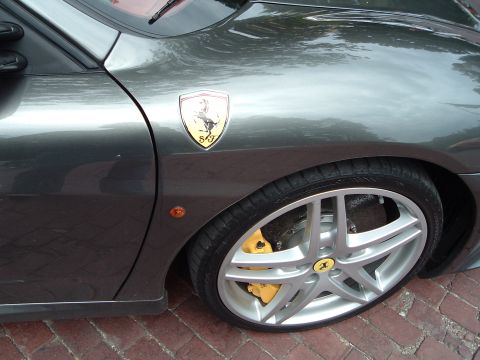1999 Mercury Grand Marquis - A close-up view of a gray Ferrari's fender, wheel, and brake system.