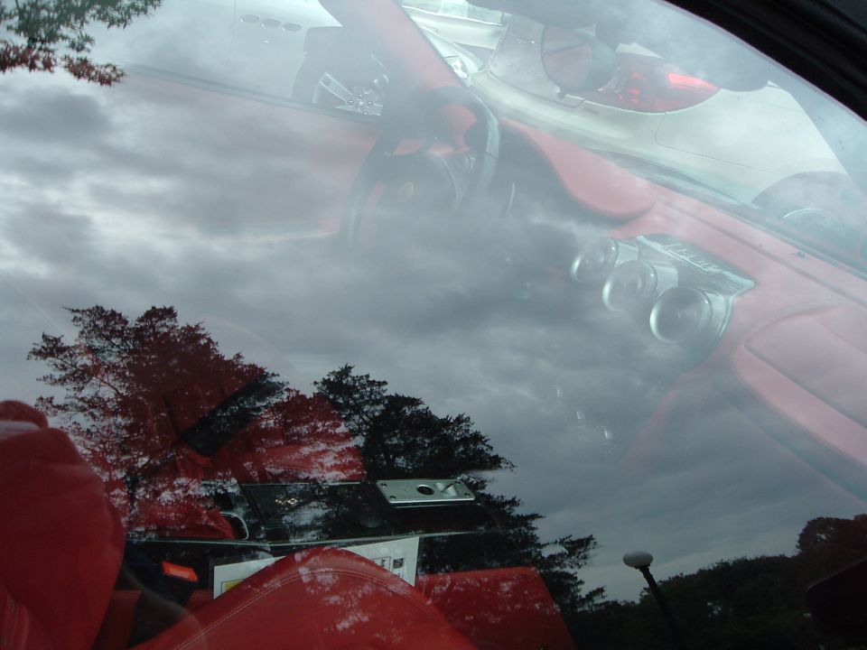 Red car interior with reflection of trees and sky