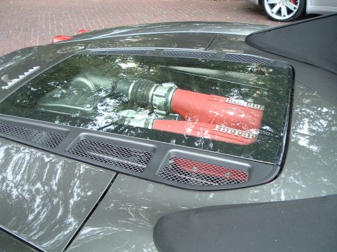 1999 Mercury Grand Marquis - Ferrari engine intake system is visible through the glass engine cover of a car.