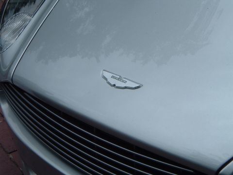 1999 Mercury Grand Marquis - The iconic Aston Martin wings emblem is visible on the hood of a silver car, above the horizontal grille.