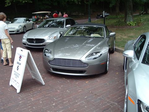 1999 Mercury Grand Marquis - Aston Martin Vantage on display at a car show, with other luxury vehicles nearby.