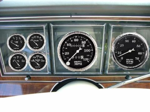 1988 Mercury Grand Marquis - Aftermarket gauges installed on a vehicle's dashboard, including a speedometer and tachometer.