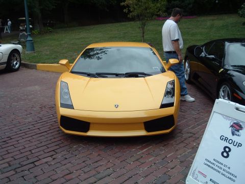 1999 Mercury Grand Marquis - A yellow Lamborghini Gallardo is parked on a brick road next to a black Ferrari F430.