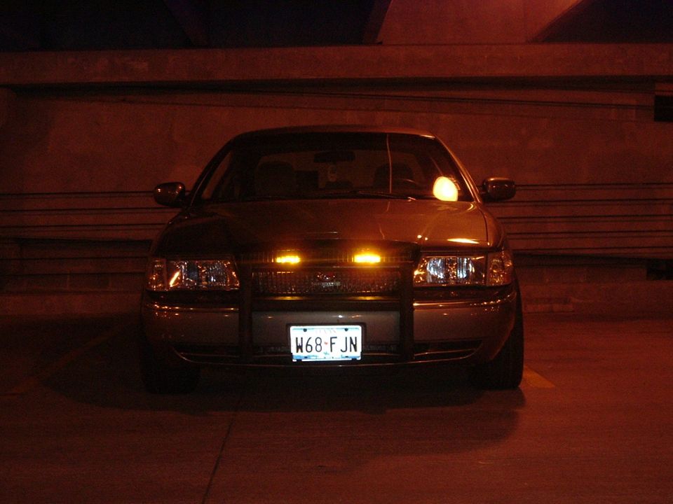 Front view of a police car with a push bar and emergency lights on the grille