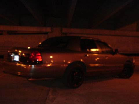 2003 Mercury Grand Marquis - A 2003 Mercury Grand Marquis sedan is viewed from the rear at night under artificial lighting.