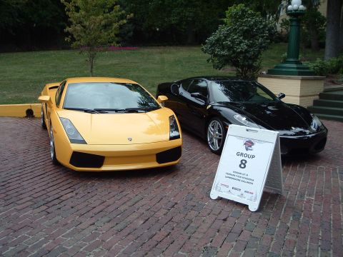 1999 Mercury Grand Marquis - Two exotic sports cars, a yellow Lamborghini Gallardo and a black Ferrari F430 Scuderia, are displayed next to a group sign.