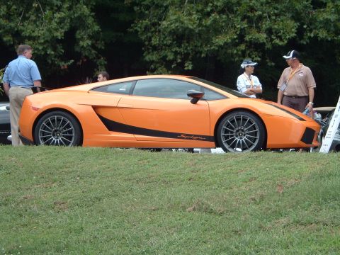1999 Mercury Grand Marquis - An orange Lamborghini Gallardo Superleggera is parked on a grassy area with people observing.