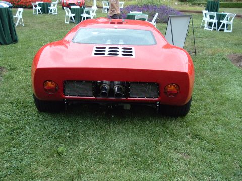1999 Mercury Grand Marquis - Rear view of a red sports car, quad exhaust pipes and a louvered engine cover.