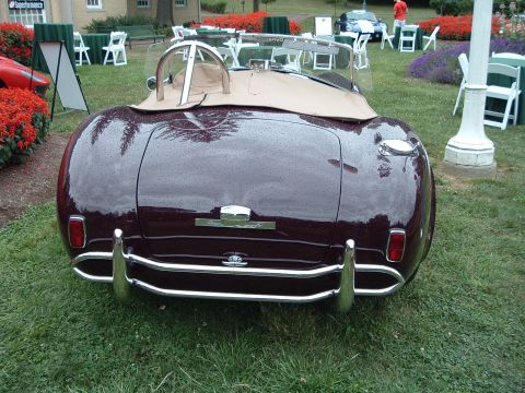 1999 Mercury Grand Marquis - Rear view of a maroon convertible with a tan top and chrome bumper, parked on grass.