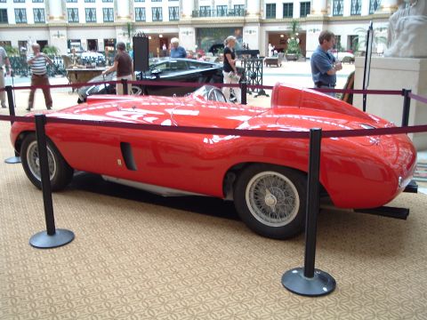 1999 Mercury Grand Marquis - A classic red sports car with a distinctive aerodynamic shape is displayed indoors.