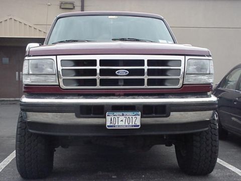 1996 Ford Bronco - This Ford F-150 pickup truck features a prominent chrome grille and bumper, with a clear view of its front end and license plate.