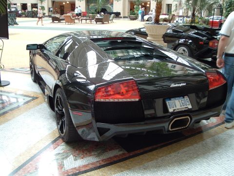 1999 Mercury Grand Marquis - A black Lamborghini is parked inside a building with a tiled floor and palm trees.