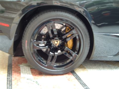 1999 Mercury Grand Marquis - A close-up view of a car's wheel and tire, revealing a yellow brake caliper and a distinctive emblem.
