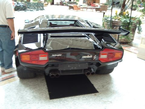 1999 Mercury Grand Marquis - Rear view of a black Lamborghini Countach, a prominent rear wing and quad exhaust pipes.