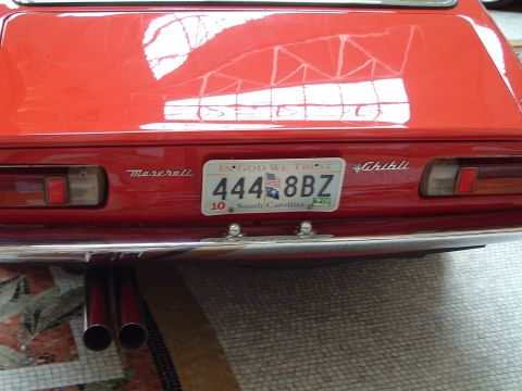 1999 Mercury Grand Marquis - Rear view of a red Maserati Ghibli, showing the Ghibli script and license plate.