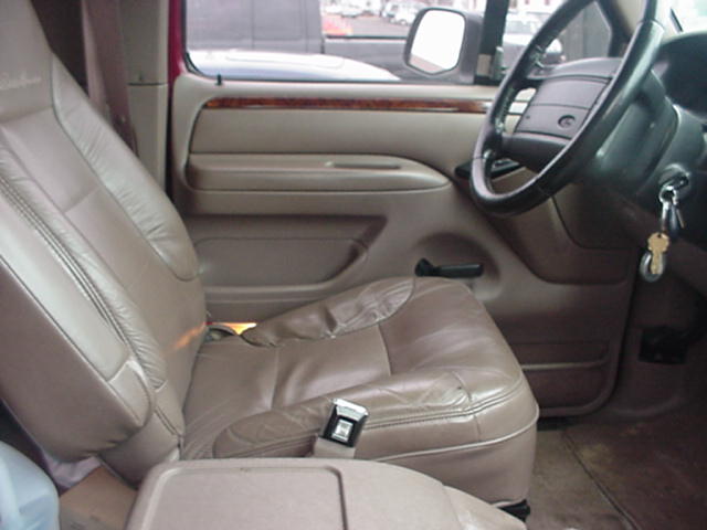 Tan leather interior of a 1996 Ford Bronco, showing the driver's seat and dashboard