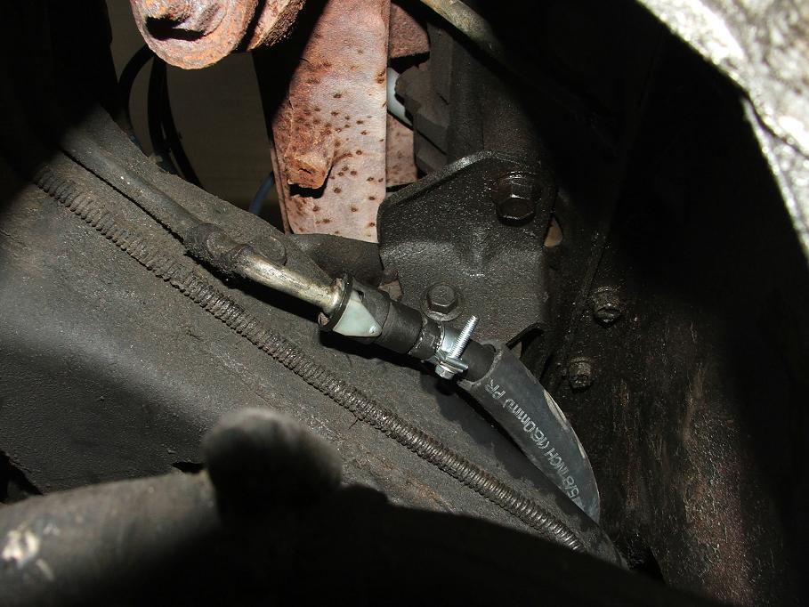 Close-up of a brake line and hose assembly with a clamp and metal fittings