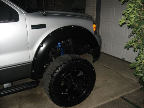1979 Ford Bronco - Close-up view of a silver pickup truck's front fender, wheel, and fender flares.
