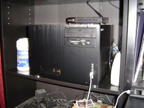 1989 Ford Bronco - Computer tower setup with peripherals and cleaning supplies on a shelf.