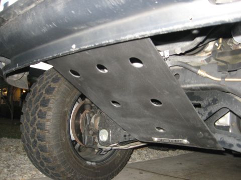 1979 Ford Bronco - Close-up view of a vehicle's underbody skid plate and tire, with visible text from Supermotors.net.