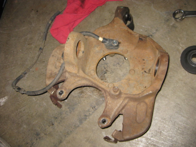 rusted steering knuckle with ABS sensor and brake line attached